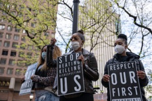 Police Brutality Legal Funding | Apply for Free | Get Up to $1 Million Three African American women hold signs against police brutality and for social justice in a New York protest.