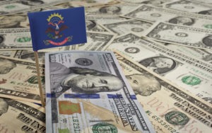 Lawsuit Loans in North Dakota | Quick Approval | Apply for Free north dakota flag sticking out of money