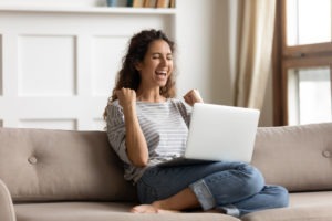 woman excited about good news on her laptop