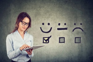business woman gives happy face rating on tablet
