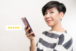 woman holding phone gives five-star rating