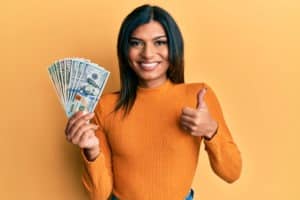young happy woman holding dollars